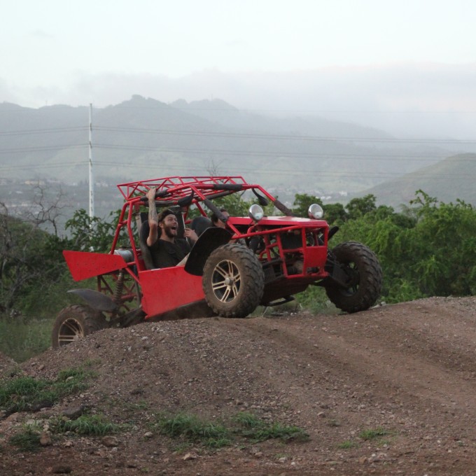 Red ATV Going Over Hill