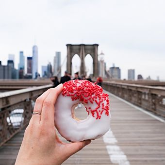 White and Pink Donut in Front of Bridge and City