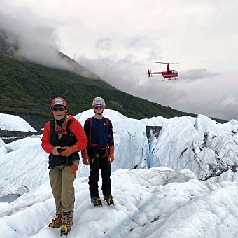 Two People in Front of Helicopter on Glacier