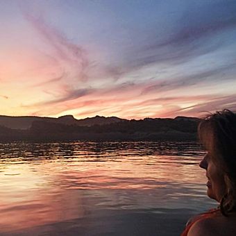 Woman Looking at Sunset Over Lake
