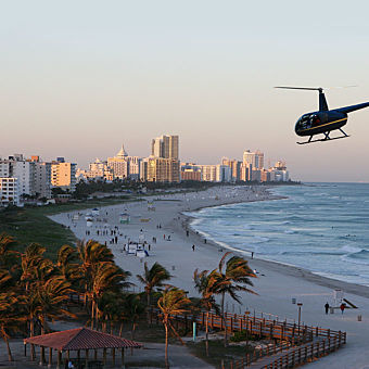 Helicopter Flying Over Beach and Downtown 