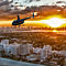 Helicopter at Sunset Over City with Skyline Background