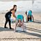 Instructor Helping Woman with Yoga Pose on Beach