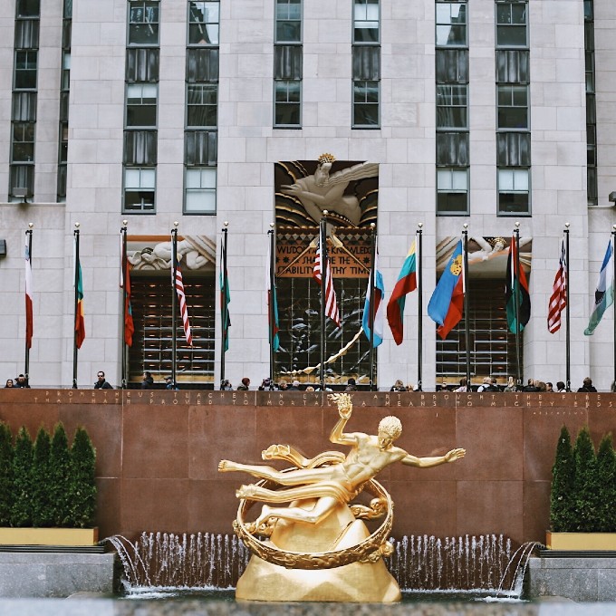 Statue and Flags in Front of Building