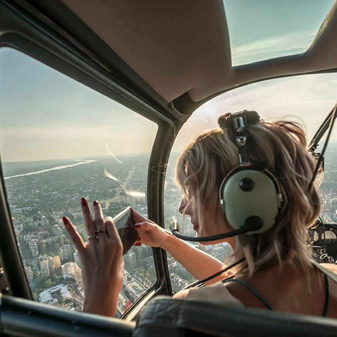 Girl in Helicopter Looking out Window and Taking Pictures