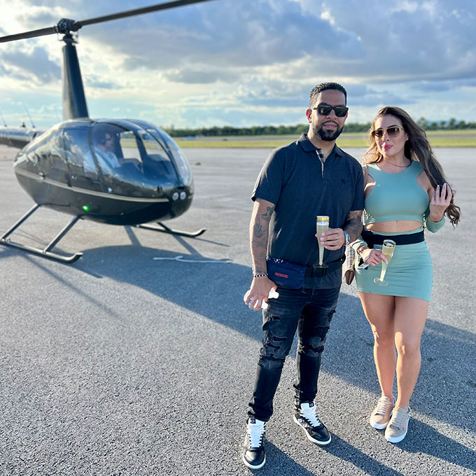 Couple with Champagne in Front of Helicopter